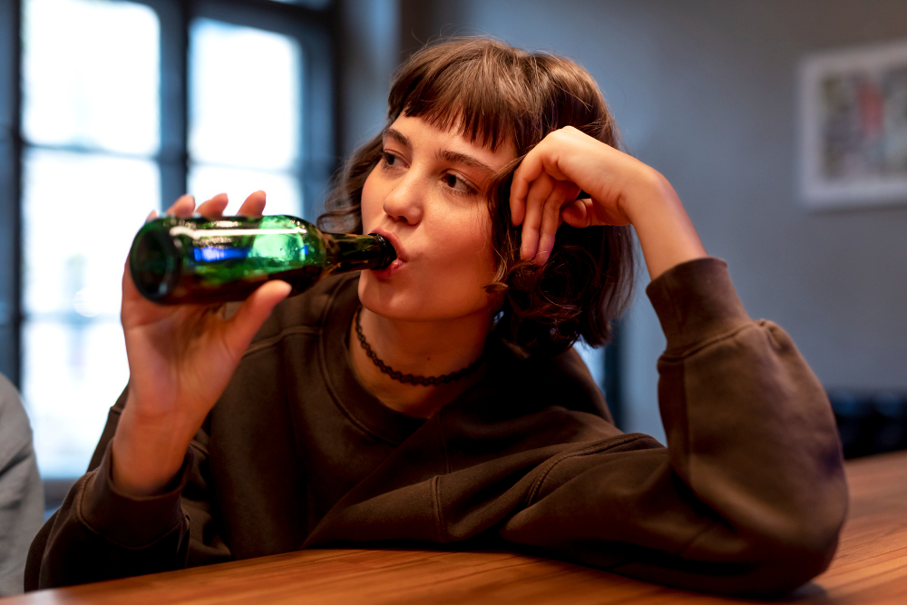 Young person drinking alcohol while considering whether they can start Suboxone or Vivitrol without stopping first.